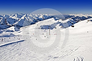 Snowy ski slope with skiers in the Alps