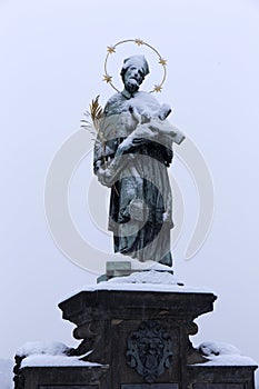 Snowy St. John of Nepomuk Statue on Prague Charles Bridge, Czech republic