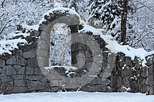 Snowy and stony ruins in woodland