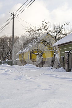 Snowy village, village with snowy road and houses in Belarus