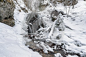 Snowy waterfall called Nizny Jamisny vodpad in winter forest, Slovakia