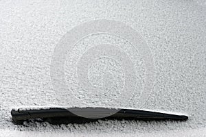 Snowy windshield on a car with wipers. Winter concept for traffic and road safety