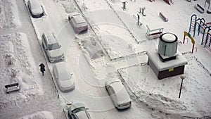 Snowy winter in the city. Top view of the parking lot. Road is covered snow, car