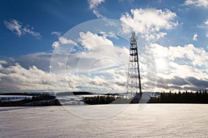 Snowy winter country with transmitters and aerials on telecommunication tower