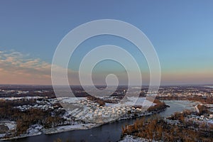 During a snowy winter landscape, an American townhome complex lies near a small river residential street after a