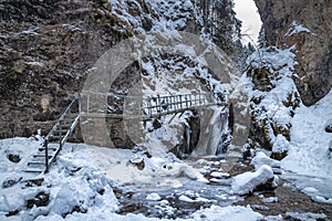 Zasněžená zimní krajina s mostem na turistické stezce přes