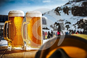 Snowy winter mountain background.  Glasses of beer and space for products and decorations.