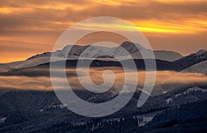 Snowy winter mountain landscape and colorful sky due sunrise over hill Dumbier in Low Tatras mountains at Slovakia