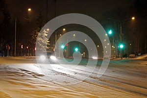 Snowy winter road with cars driving on roadway in snow storm