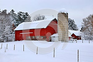 Snowy winter rural landscape with red barn