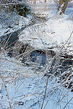 A snowy winter scene by a river