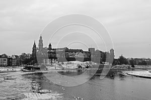 Snowy winter view of Wawel Castle seen from across the Vistula River. Its a cold, cloudy day.Krakow, Poland. Black and white