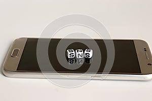 `SNS` alphabetical white cube on Smart phone.