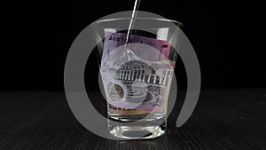 Soak Australian Dollars in a glass filled with isopropyl alcohol and water. The science concept of burning money without damage