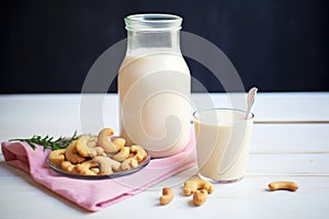 soaked cashews next to a jug of fresh cashew milk