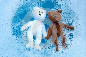 Soaking bear toys in laundry detergent water dissolution before washing. Laundry concept