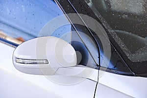 Soaking side mirror of white car