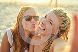 Soaking in the sun and the fun. young female best friends hanging out at the beach.