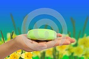 Soap bar in hand on abstract background.
