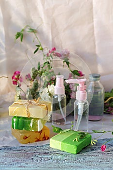 Soap, a bouquet of medicinal herbs and glass bottles with aromatic oil on a wooden table