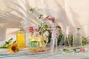 Soap, a bouquet of medicinal herbs and glass bottles with aromatic oil on a wooden table