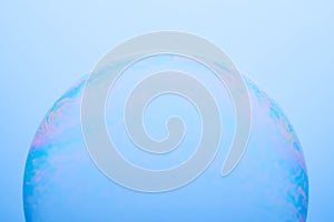 A soap bubble isolated on a blue background. Abstract photo.