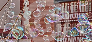 Soap bubbles with deliberately blurred half-timbered buildings in the background