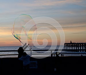 Soap bubbles floating during a sunset near Pacific beach boardwalk - 1
