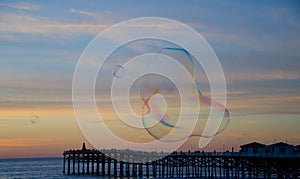 Soap bubbles floating during a sunset near Pacific beach boardwalk - 5