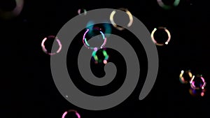 Soap bubbles fly and burst in the air. Slow motion. Black backgrounds