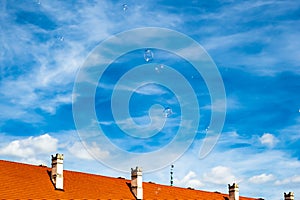 Soap Bubbles fly in the sky. Background bright, blue sky and fluffy white clouds