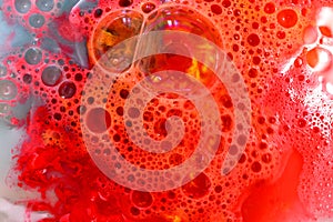 Soap bubbles on red liquid background.