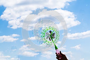 Soap bubbles toy with propeller. Soap bubble in front of a blue sky in the sun. Childrens soap bubble toy