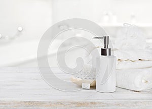 Soap dispencer, towels, massager and wisp of bast over blur photo