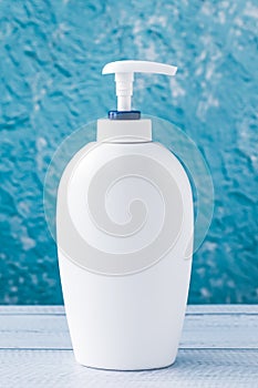 A soap dispenser bottle. Hygiene concept. Antibacterial gel for washing hand on a blue background. Sanitizer spray. Moisturizer