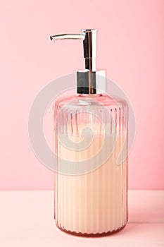 Soap dispenser on pink background. Vertical photo