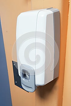 Soap hand sanitizer dispenser hanging on the wall to disinfect hands automatic alcohol
