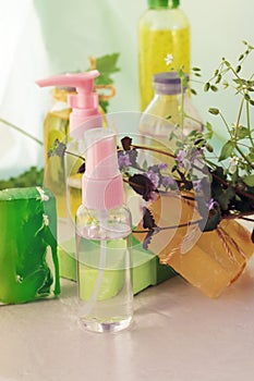 Soap, herbs, spray and bottles with aromatic oil on a wooden windowsill