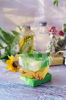 Soap, herbs, spray and bottles with aromatic oil on a wooden windowsill, natural homemade cosmetics