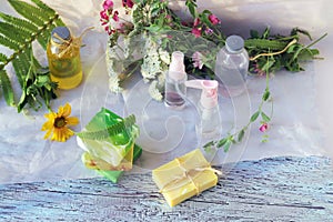 Soap, herbs, spray and bottles with aromatic oil on a wooden windowsill, natural homemade cosmetics