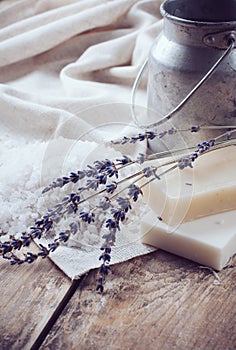 Soap, lavender, salt and old can on wooden board