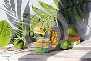 Soap, limes, aromatic oil on a wooden table