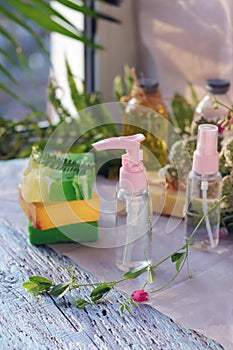 Soap, spray, bouquet of medicinal herbs and glass bottles with aromatic oil on a wooden table