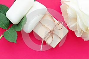 the soap is tied with a rope and a white rose on a pink background with a place for the inscription. Concept of hygiene and Spa