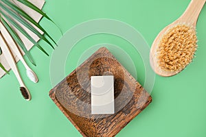 Soap in a wooden substrate, toothbrushes, paper bags, a body wash brush on a green background with grass