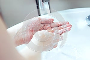 Soaped hands in modern bathroom