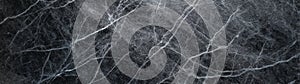 Soapstone marble with fine white veins on dark textured background in panoramic view photo