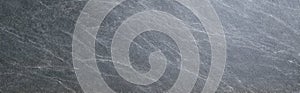 Soapstone slab with honed finish and fine diagonal grey grain texture photo