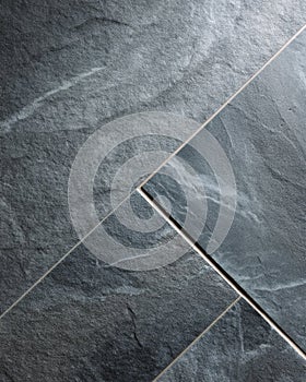 Soapstone tile in dark grey with rough honed texture arranged in offset pattern photo