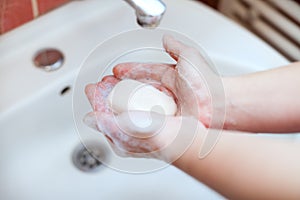 Soapy hands holding soap for hand washing